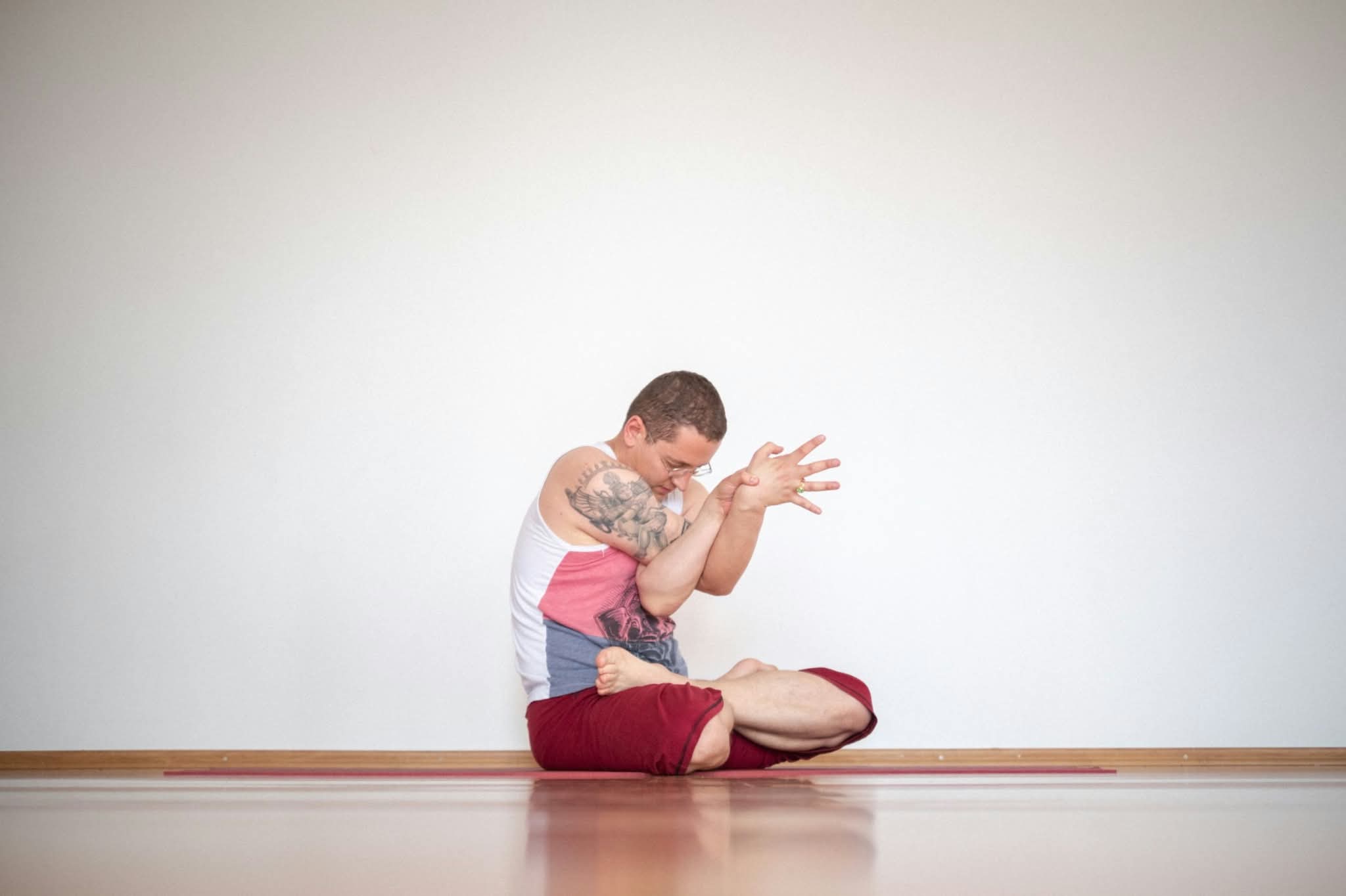 Andrija u sjedećem yoga položaju s Eagle položajem ruku